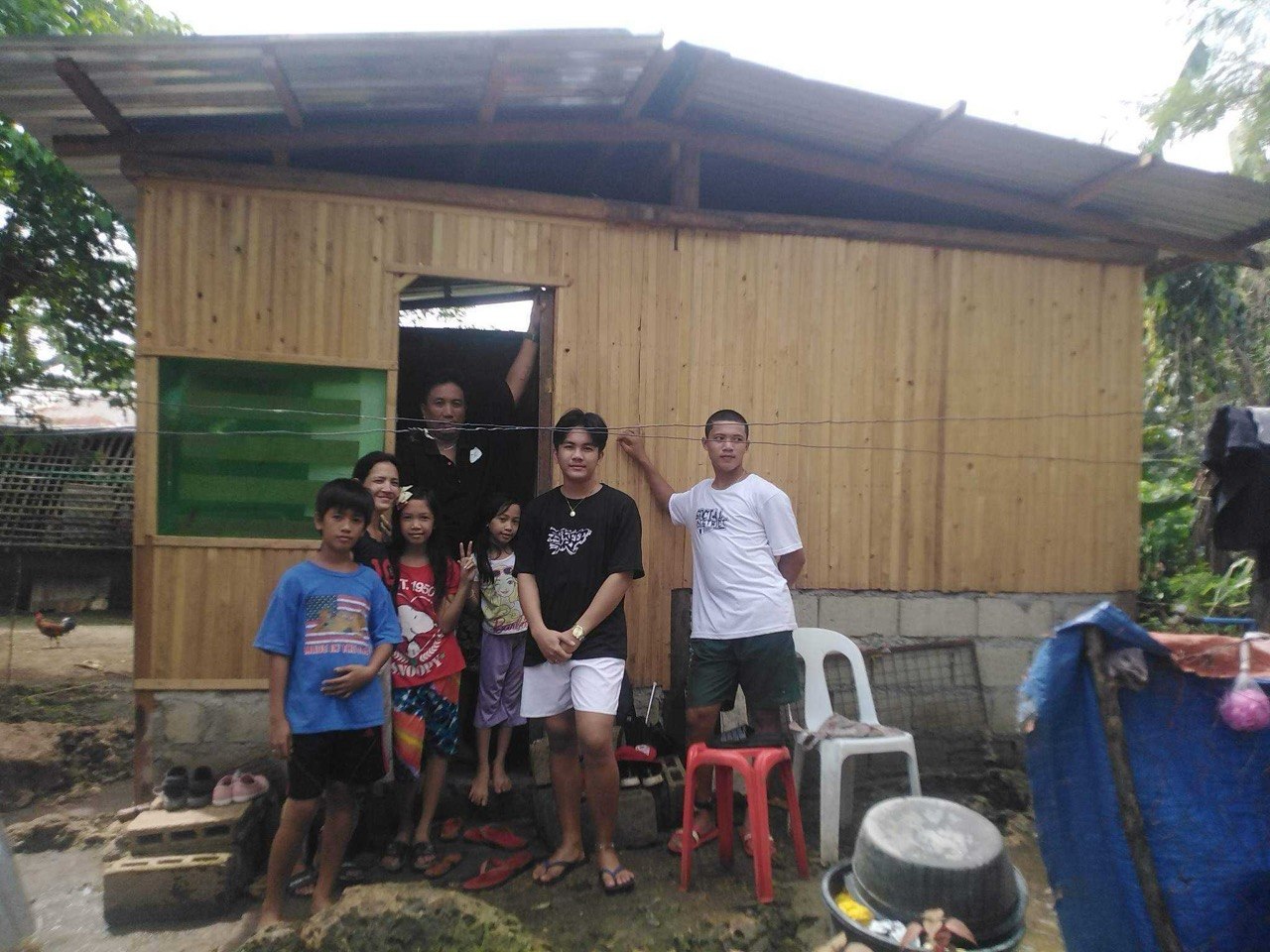 Kuya Jeffrey with his family in front of their rebuilt home